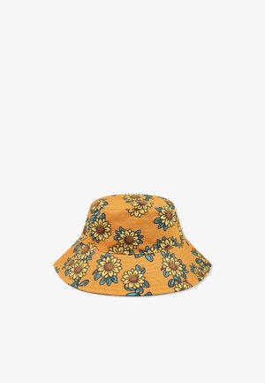 Chapeau seau en tissu jaune moutarde avec un motif de tournesols, centres marron et feuilles vertes. Large bord et design structuré.