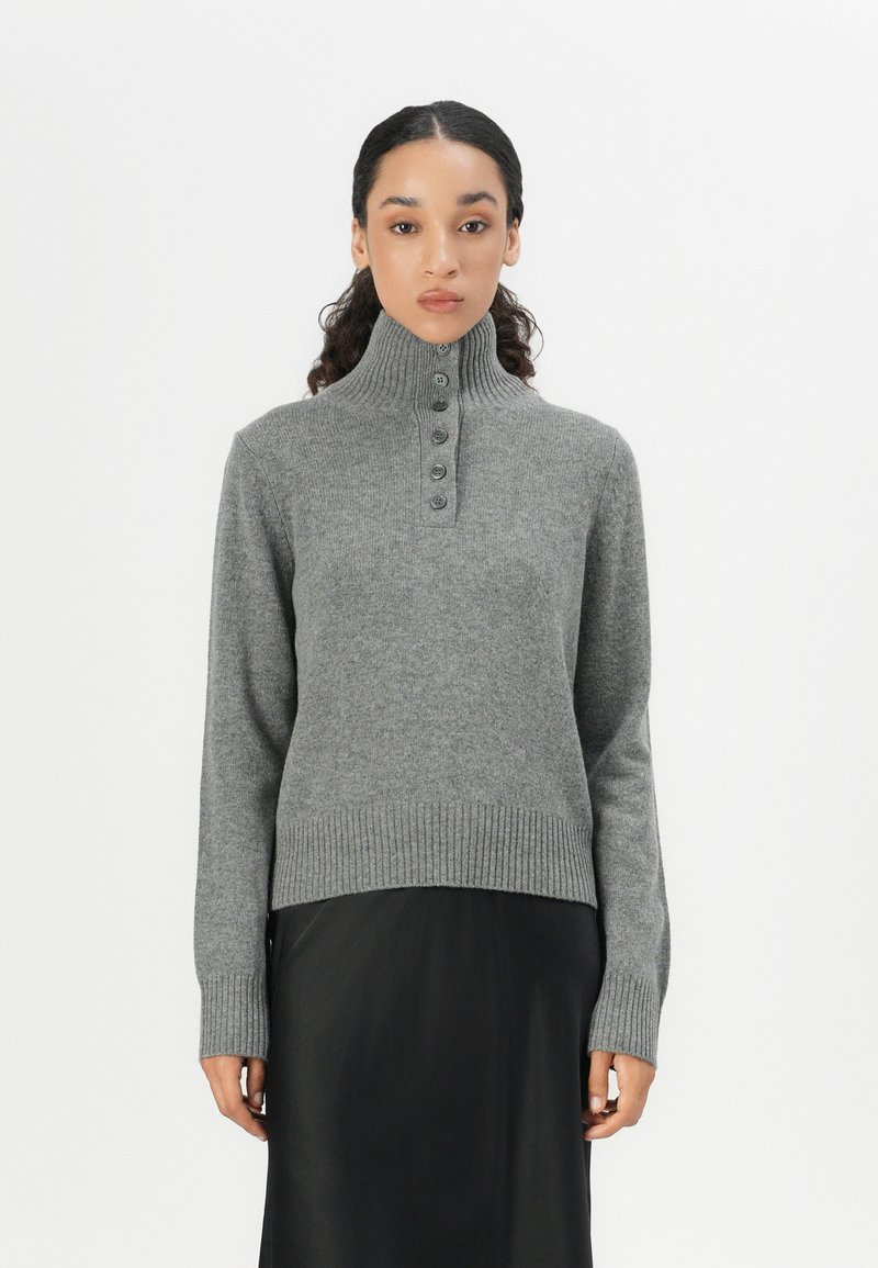 Pull en mélange de laine gris avec un col haut à côtes, une patte de boutonnage et un ourlet et des poignets côtelés. Texture lisse, silhouette ajustée.