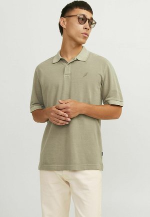 Oliven Grøn polo t-shirt i blødt stof, med krave og korte ærmer, samt en diskret broderet logo på venstre bryst.