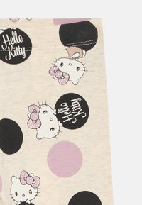 Šviesiai smėlio spalvos audinys, kuriame pavaizduoti Hello Kitty veideliai ir juodi apskritimai su užrašu "Hello Kitty", papuošti violetiniais taškais.