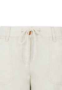 Beige shorts met een verstelbare tailleband en een houten toggle. Voorzien van twee voorzakken en contrasterende stiksels. Katoenachtige textuur.