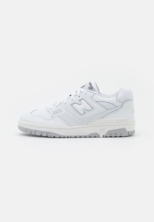 Sneaker sportive bianche con upper in pelle perforata, punta rotonda, colletto imbottito e suola in gomma testurizzata con accenti grigi.