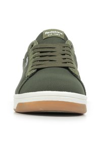 Baskets en mesh vert avec bout rond, semelle blanche plate et accents en caoutchouc. Présente des lacets vert olive et une marque sur la languette.