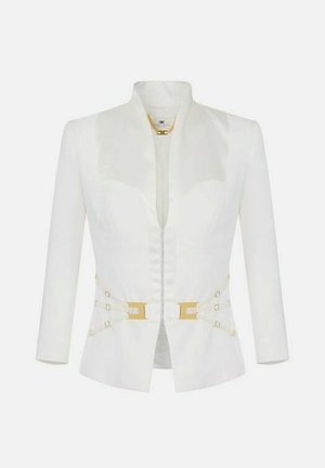 Giacca bianca sartoriale con spalle strutturate, apertura frontale, fibbie decorative dorate in vita e maniche lunghe.