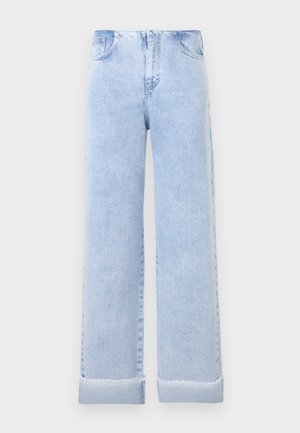 Φαρδιά τζιν γκριζοπράσινου χρώματος με γυρισμένα μανσέτα και μπροστινές τσέπες, απεικονισμένα σε απλό ανοιχτό γκρι φόντο.