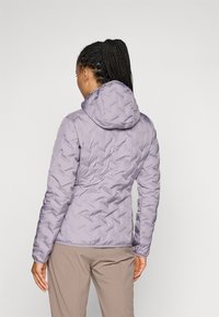 Doudoune violette claire avec capuche, présentant un surface texturée et à motifs, au design ajusté, descendant jusqu'à la taille.