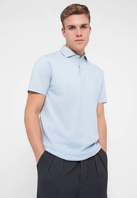 Ανοιχτό μπλε κοντομάνικο πόλο με γιακά, κατασκευασμένο από απαλό ύφασμα, με πατιλέτα τριών κουμπιών και στενή εφαρμογή.