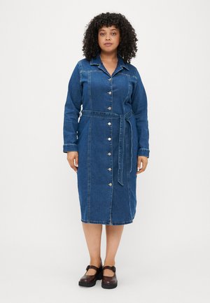 Denim kleit kraega, pikkade varrukatega ja vööga taljes. Esiküljel on hõbedased nupud ja keskmise pikkusega lõige. Tumedat sinist värvi.