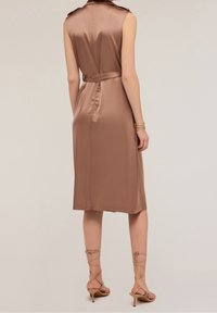 Saténové hnědé šaty bez rukávů s páskem v oblasti pasu a ramenními panely, se siluetou do kolen a hladkou texturou.