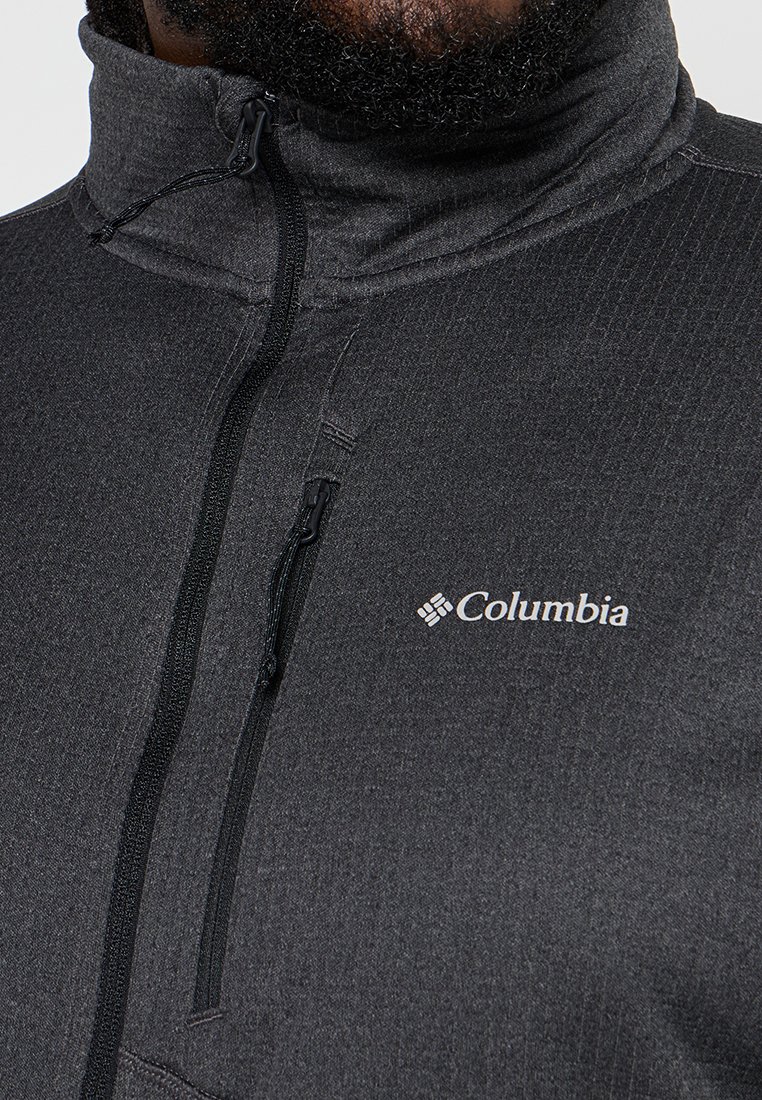 Giacca nera con zip e colletto alto, realizzata in tessuto testurizzato. Presenta una tasca con zip e un logo Columbia bianco sul petto.