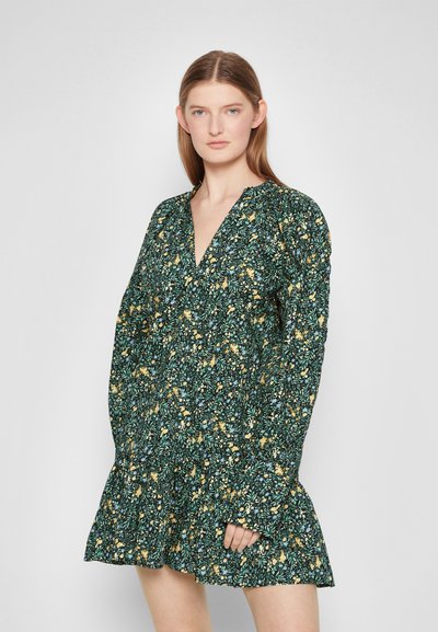 Vestido verde floral com flores amarelas e azuis, decote em V, mangas bufantes longas e bainha com ruffles, feito de um tecido leve e texturizado.