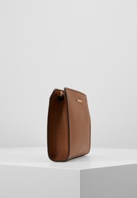 Borsa in pelle marrone con una texture liscia, forma rettangolare, dettagli in metallo dorato e chiusura con zip nella parte superiore.