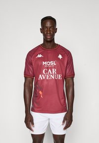 Kirsebærfarget fotballdrakt med korte ermer, ribbet tekstur og oransje detaljer. Har merkevaren "MOSL" og "CAR AVENUE" i hvit tekst.