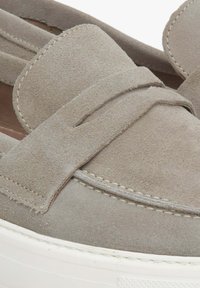 Szare zamszowe mokasyny z szerokim paskiem na górze oraz białymi gumowymi podeszwami z detalami szewskimi. Gładka faktura, minimalistyczny design.