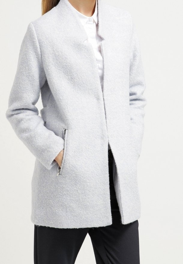 Cappotto grigio chiaro, sartoriale, realizzato in tessuto testurizzato con colletto ad ascot, tasche laterali con zip e taglio dritto. Adatto per un abbigliamento casual.