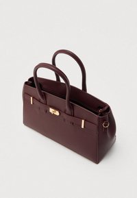 Sac à main en cuir bordeaux avec une texture lisse, double anses, accents métalliques dorés et fermeture éclair. Présente une forme rectangulaire structurée.