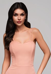 Robe couleur pêche avec un décolleté en cœur, des fines bretelles et un corsage ajusté. Texture lisse avec une silhouette élégante.