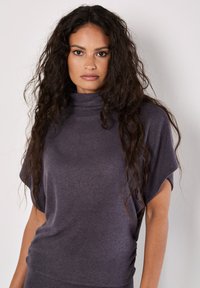 Grauer, kurzärmeliger, Stehkragenoberteil aus weichem Stoff; bietet einen lockeren Schnitt und leichtes seitliches Raffen für zusätzliche Details.