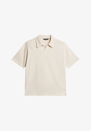 Beige polo tričko s krátkými rukávy, plochým límcem a výstřihem do V. Vyrobeno z hladké látky s minimem švů a bez vzorů.