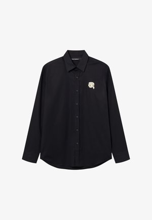 Black long-sleeve button-up shirt with a small white graphic of a stylized face wearing goggles on the left chest.