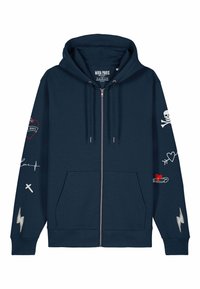 Felpa blu navy con zip e due tasche frontali. Presenta design ricamati: teschio, cuore, fulmine e dettagli testuali sulle maniche. Tessuto morbido e textured.