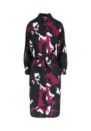 Paidatunika mustasta kankaasta, jossa on rohkea violetti ja valkoinen abstrakti kuvio, varustettuna napitettavalla etuosalla, kauluksella ja sopivalla vyöllä.