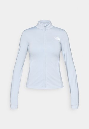 Vaaleansininen vetoketjullinen takki, valmistettu sileästä kankaasta, jossa on korkea kaulus ja pitkät hihat. Vasemmassa yläkulmassa näkyvä valkoinen logo.