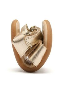 Zapato de bebé metálico dorado con una suela blanda y flexible. Presenta una abertura amplia con tiras de velcro y una textura de cuero suave.