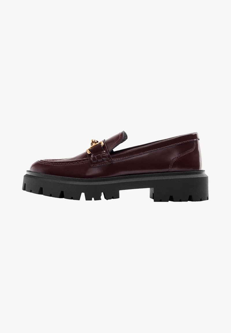 Mocassin en cuir bordeaux avec semelle épaisse à crampons noire et détail de boucle en métal doré sur le dessus.