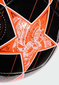 Pallone da calcio nero con stella arancione e grafica di una figura che versa un liquido. Superficie liscia con motivi contrastanti e colori vivaci.