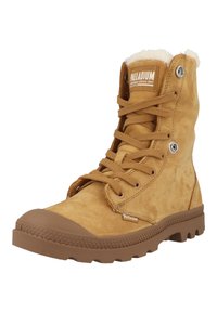 Bottines en cuir suédé tan avec un bout en caoutchouc, doublure douce et semelle texturée. Dotées d'œillets en métal et d'un logo sur la languette.
