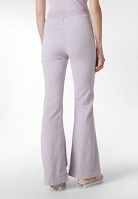 Uppsvängda byxor i ljus lavendel, tillverkade av mjukt bomullsmaterial, med hög midja och sydda detaljer vid fållen.