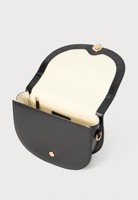 Black leather crossbody bag with a rounded flap. Interior features a beige lining and a zippered pocket, accented with rose gold hardware.