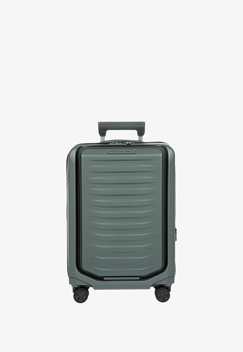 Valise rigide de couleur vert foncé, avec une surface texturée ornée de rainures horizontales, une poignée rétractable et quatre roues pour la mobilité.