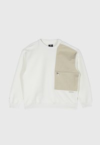 Sudadera blanca con un panel texturizado beige en el lado izquierdo, que incluye un bolsillo con cremallera y puños acanalados. Diseño minimalista con detalle del logo.