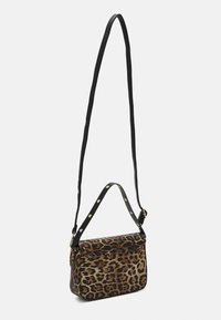 Leopardo printta oleva suorakaiteen muotoinen olkalaukku, jossa on pitkä säädettävä musta hihna ja lyhyempi niititetty kahva valkoista taustaa vasten.