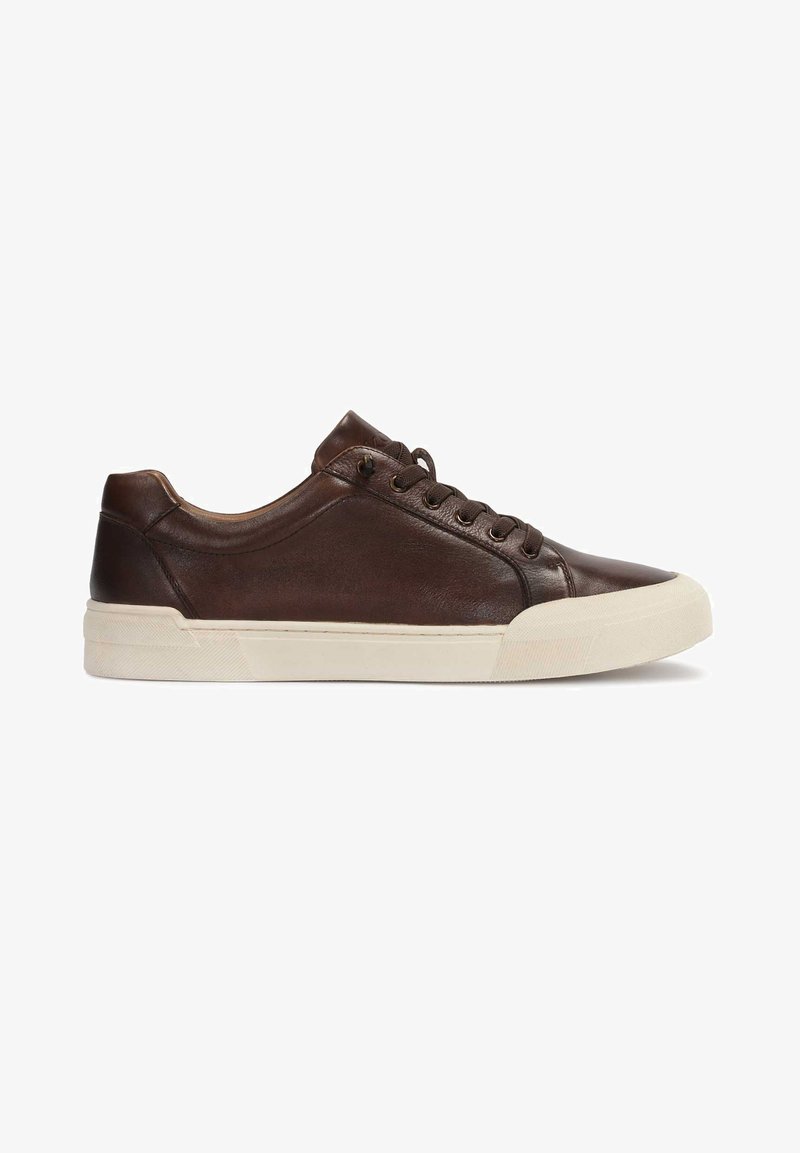 Zapatilla de cuero marrón con puntera redondeada, diseño con cordones, suela de goma crema y sutiles detalles de costura en los lados.
