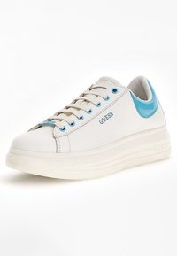 Bílé tenisky s modrými akcenty, hladký syntetický materiál, kulatá špička, plochá podrážka a výrazné logo "GUESS" na boku.