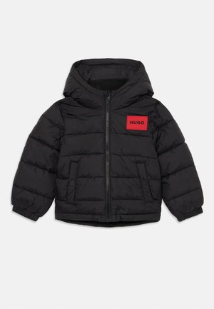 Black padded jacket with a hood, featuring a red rectangular logo patch labeled "HUGO" on the chest and elastic cuffs.