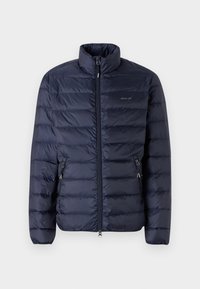 Marineblauwe pufferjack met een ritssluiting aan de voorkant, hoge kraag en horizontale stiksels, met zijzakken met ritsen.