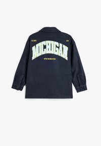 Marineblå flannel skjorte med "MICHIGAN" i store gule bogstaver på ryggen, med knappede manchetter og en løs pasform.