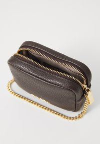 Bruine leren tas met een gestructureerde afwerking, dubbele gouden ritsen en een gouden kettingband. Compact rechthoekig model met een gestroomlijnd ontwerp.