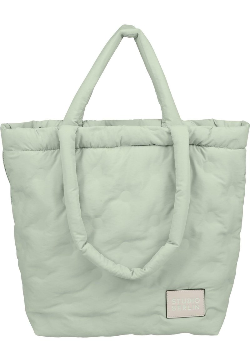 Lys grøn puf tote bag med to håndtag, tekstureret overflade med forhøjede prikker og et syet mærke med "STUDIO BERLIN" i pastelfarver.