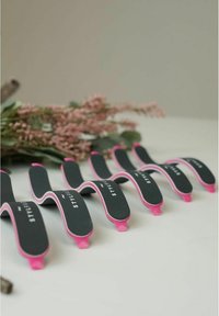 Pink and black wave-shaped hair tools with curved design; soft texture; "STYLISH" printed on the black section; no visible hardware.