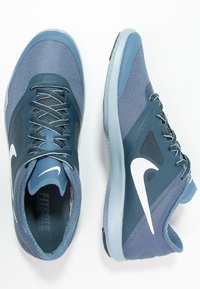 Sport shoes featuring a composite mesh and synthetic upper in shades of blue, with a white Nike logo and textured rubber sole.