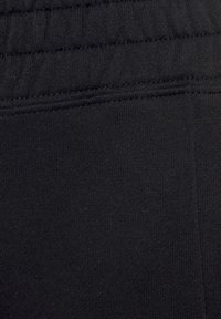 Schwarzer elastischer Taillenbund mit feiner gerippter Textur; glatt, dehnbares Material in einfarbig schwarz; keine sichtbaren Muster oder Hardware.