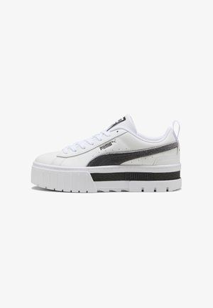 Weißer Puma-Sneaker mit schwarzem Streifen, dicker Sohle mit schwarzem Mittelteil, Schnürverschluss vorne und Zuglasche an der Ferse, Seitenansicht.