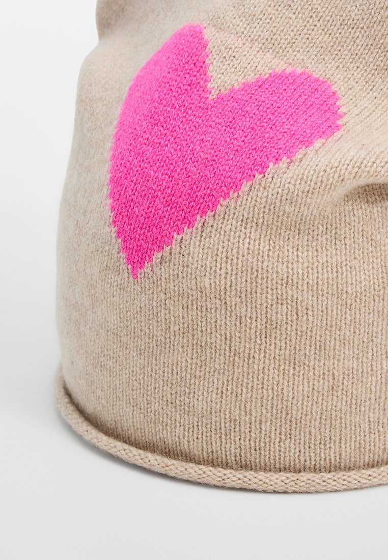 Beige gestrickte Mütze mit einem großen rosa Herzdesign. Die Textur ist weich mit einem leichten Stretch und einem umgeschlagenen Saum an der Basis.