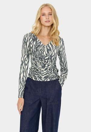 Haut à manches longues au motif zèbre, avec un col en V et des détails froncés à la taille, fabriqué en tissu extensible crème et bleu marine.