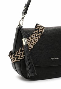 Czarna torebka o teksturowej powierzchni z dekoracyjnym wplecionym paskiem z wzorami w zygzak, srebrnymi elementami metalowymi oraz szczegółem w postaci fryzury z boku.